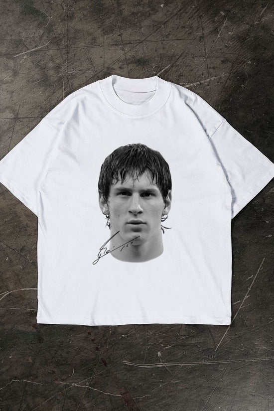 White t-shirt with a black and white graphic of a Lionel Messi on a textured dark surface
