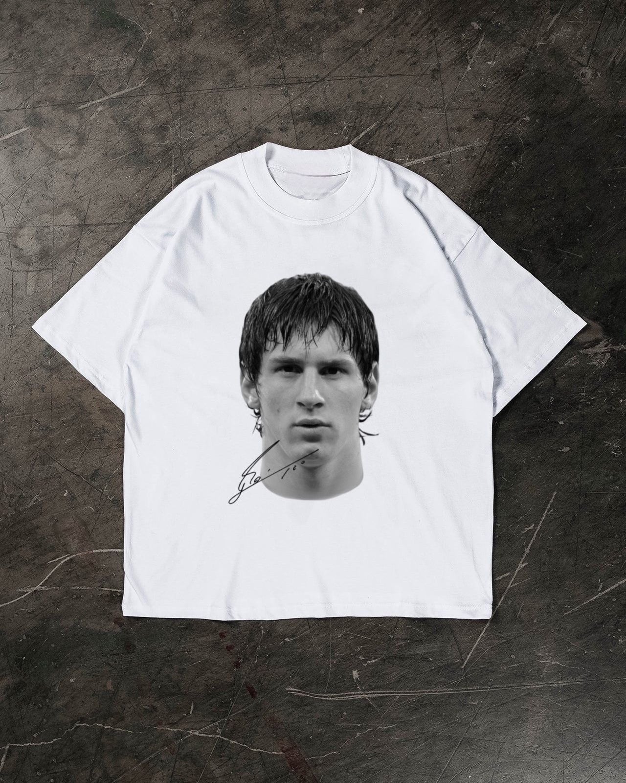 White t-shirt with a black and white graphic of a Lionel Messi on a textured dark surface